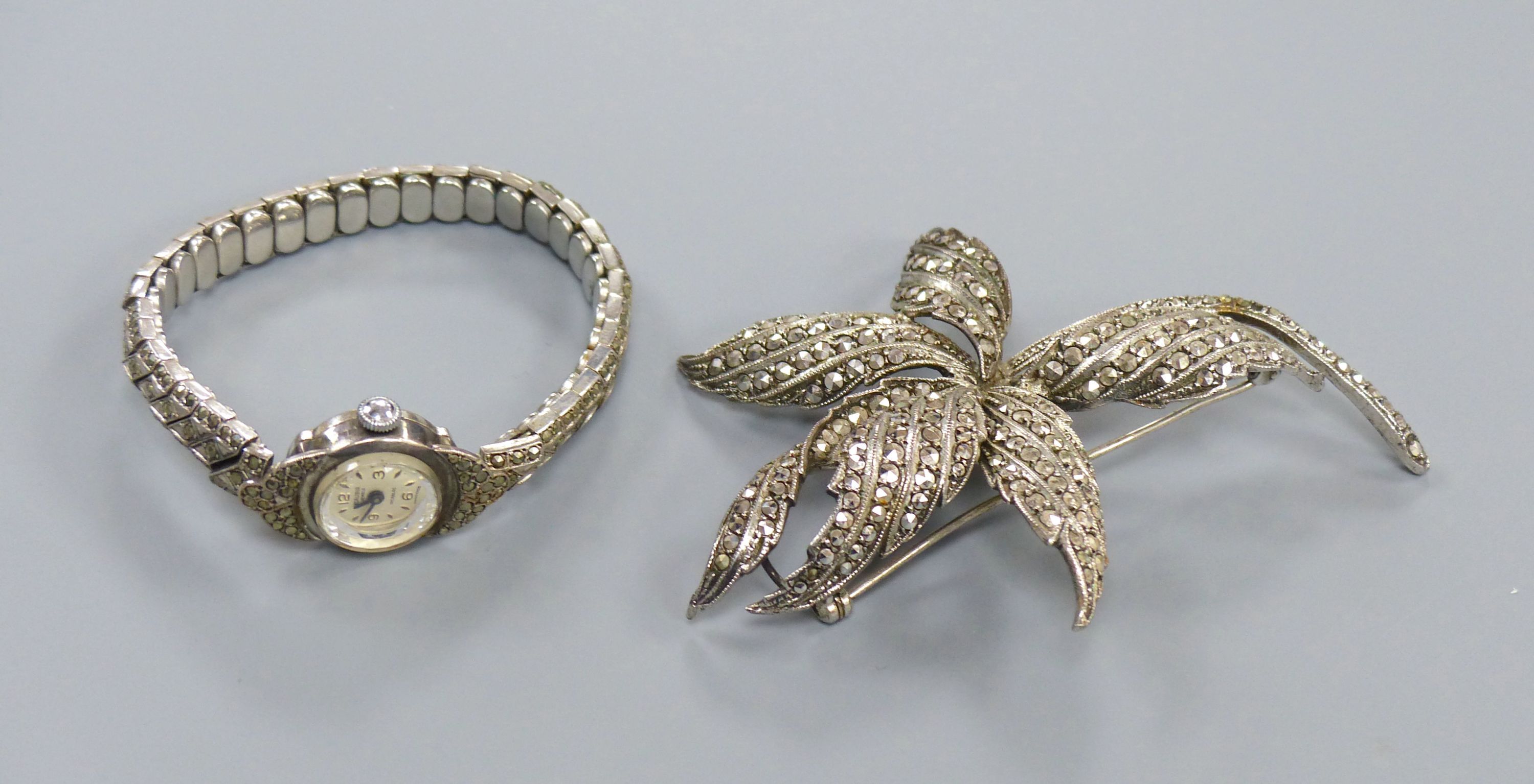 A 1960's silver and marcasite floral spray brooch and a lady's silver and marcasite wrist watch.